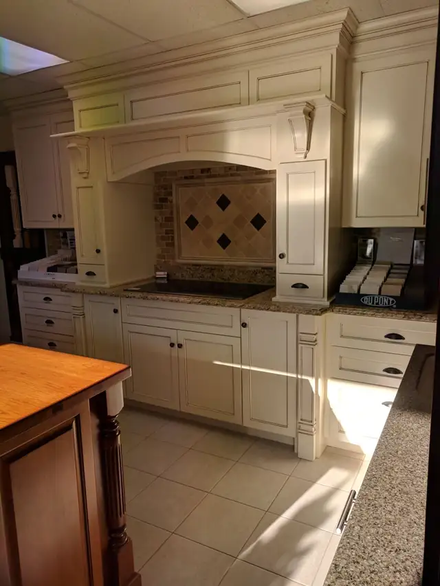 Cream cabinets with arched hood surround, diamond tile backsplash and granite counters